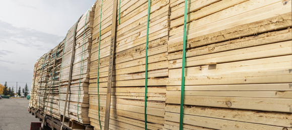 Stacked lumber on the back of a flatbed truck.